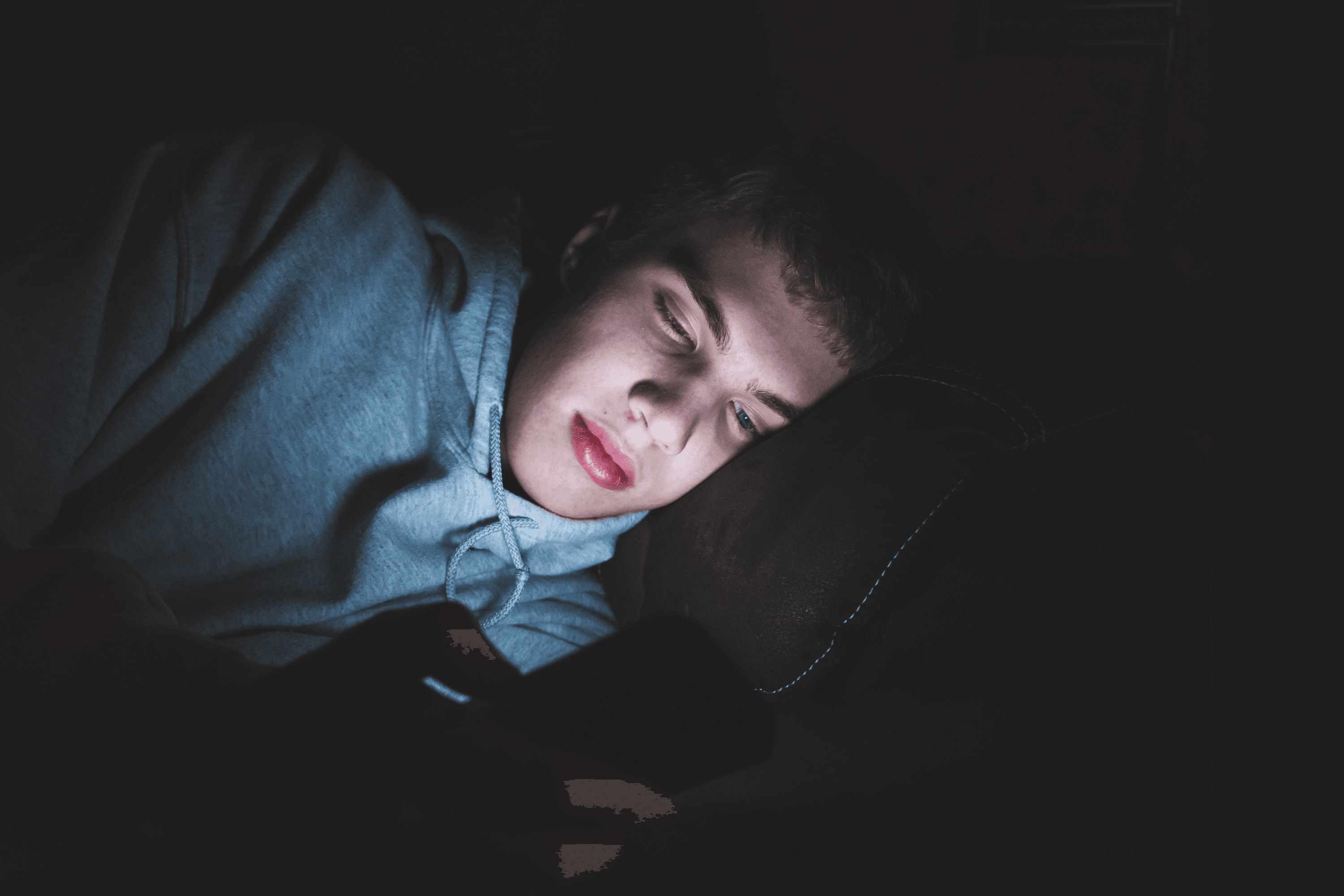 Boy looking at his phone late at night